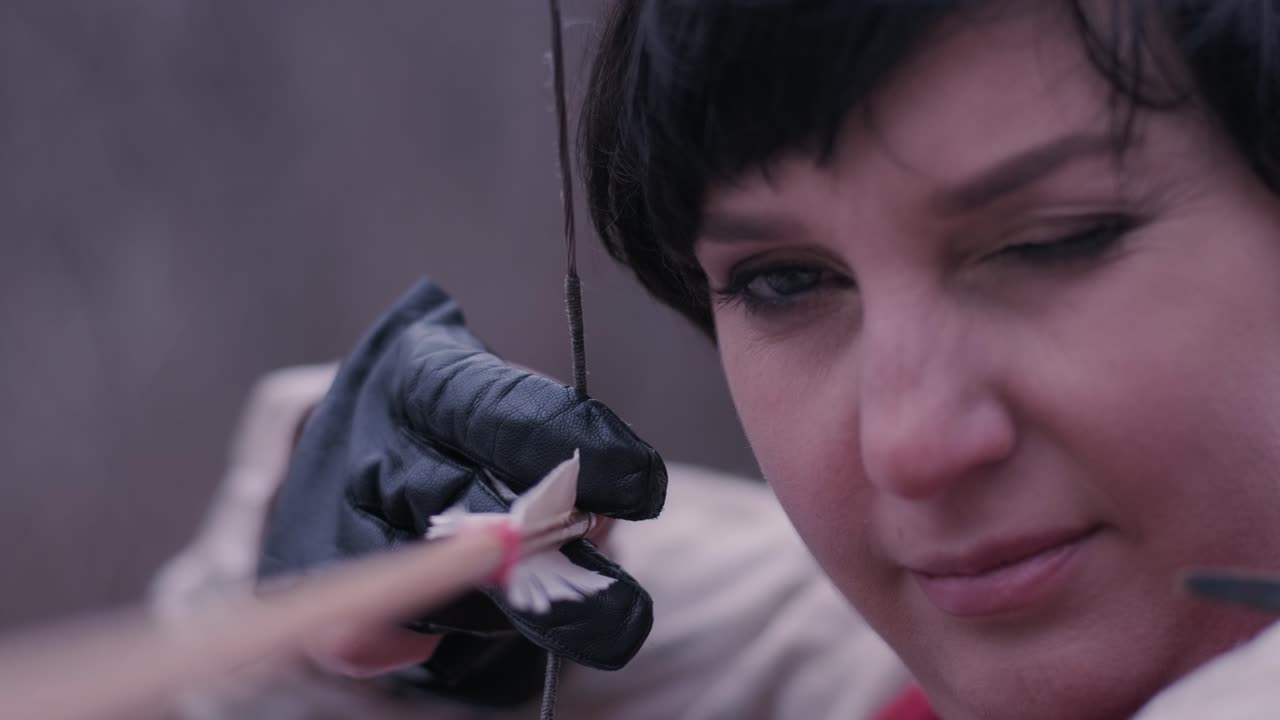 женщина-воин стреляет луком в цель.