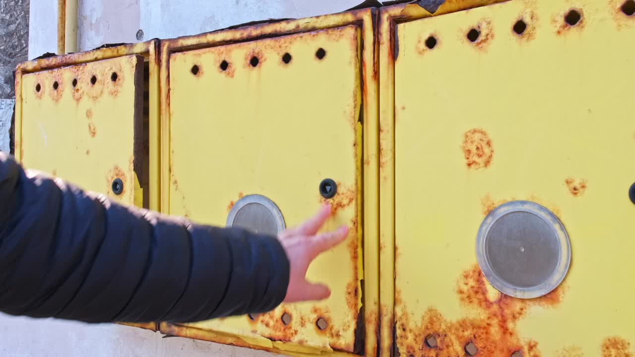técnico caucásico masculino abriendo la caja vacía del medidor de gas unida a la pared de un edificio residencial desconectado de la red de tuberías durante la crisis.