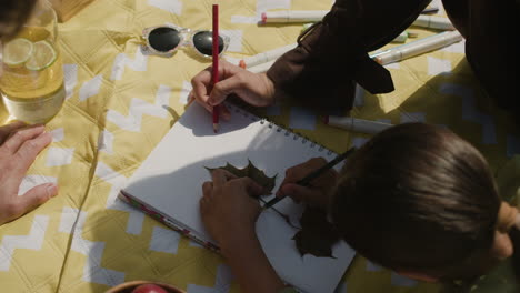 people having a picnic and drawing nature