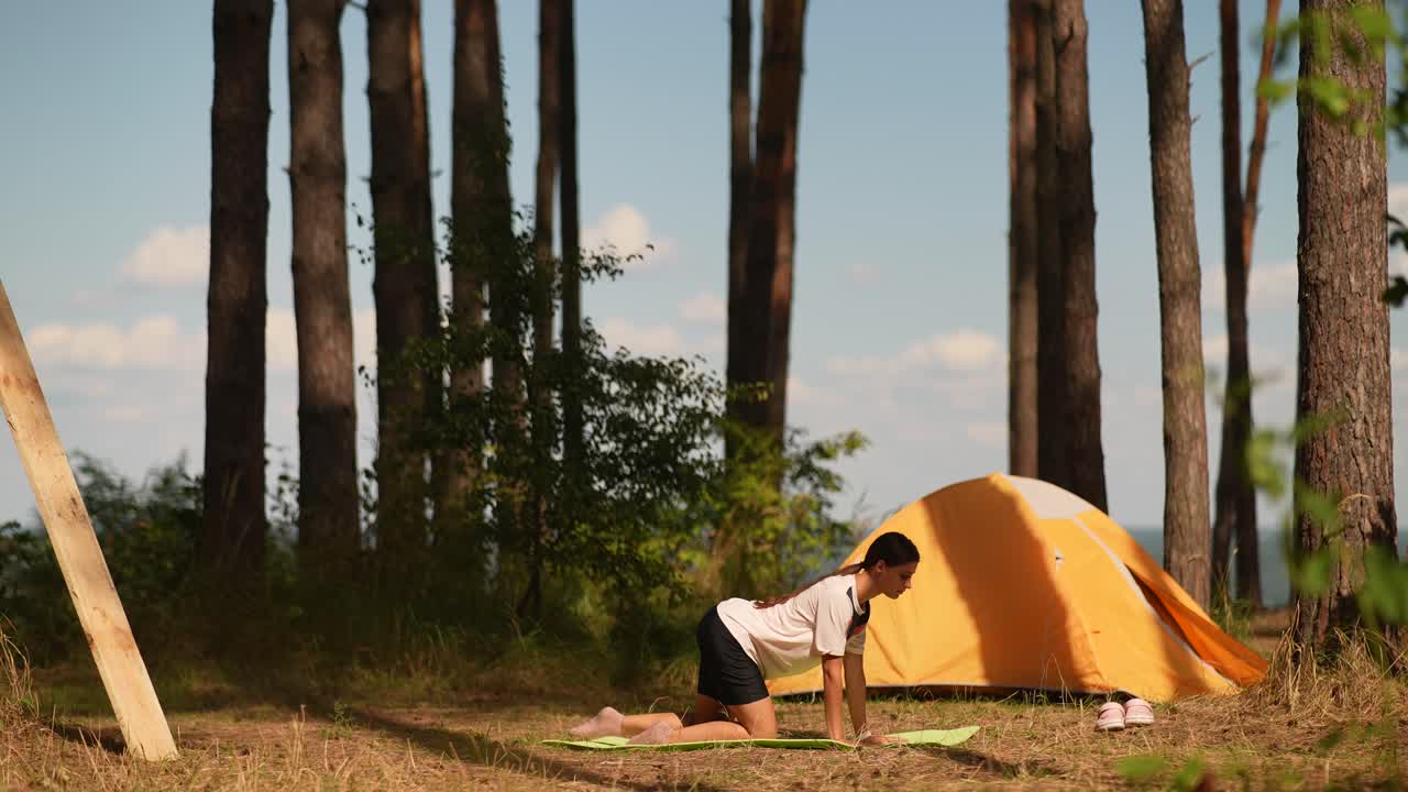 캠핑 텐트 근처의 숲에서 요가