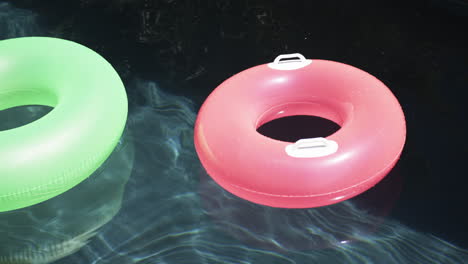 two colorful swim rings float on the water's surface