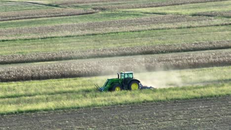 tracking drone shot of tractor harvesting seeds and