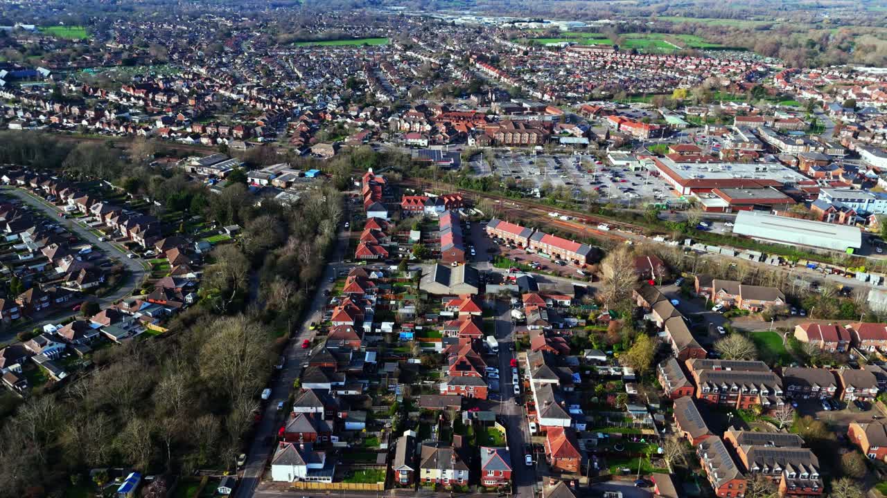 Luftpanoramaoptagelse over Totton-forstaden vest for floden i Southampton, England, med biler, der kører på de travle veje, og sollys, der reflekteres på det blå flodvand med både på den om vinteren.