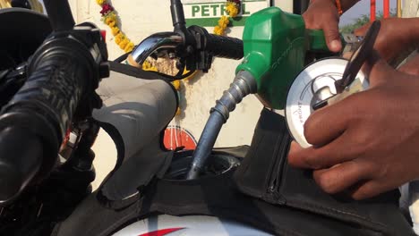 llenar la gasolina usando el dispensador de gasolina en el tanque vacío de la bicicleta en india