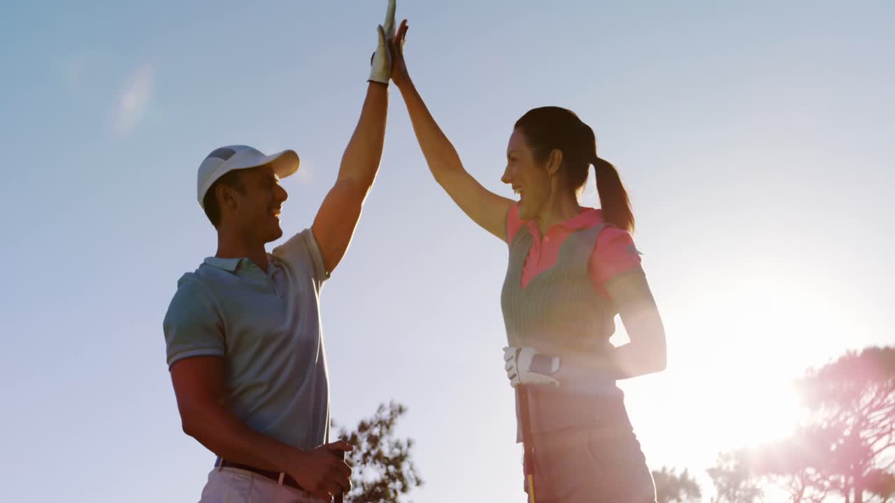 Two happy golfers giving high five