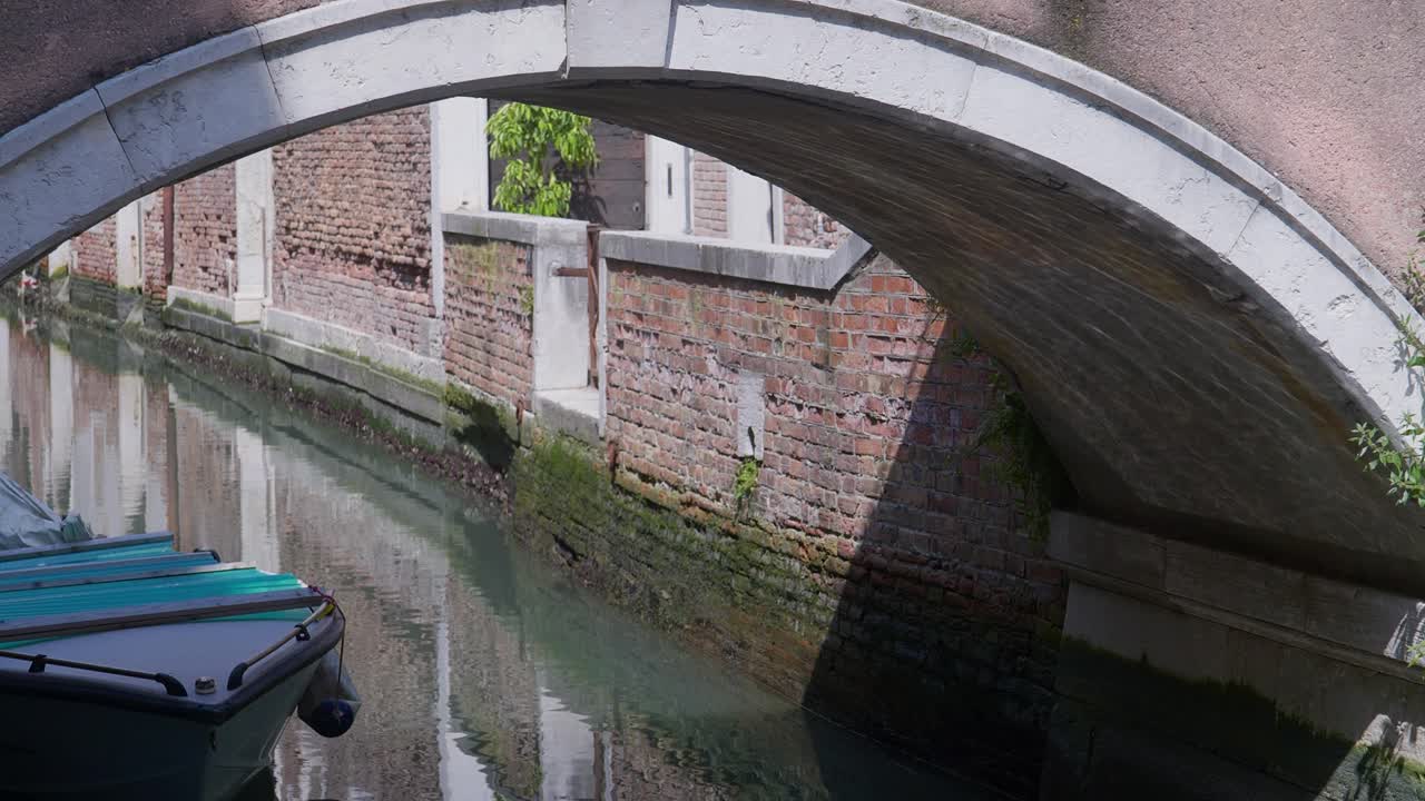 Shimmering water reflections ripple under canal bridge surface