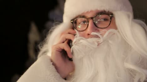 old santa claus and modern digital technologies tired of social networks old santa claus and modern digital technologies tired of social networks surprised by the letter and wishes from children christmas decoration with new year tree garlands and holiday lights