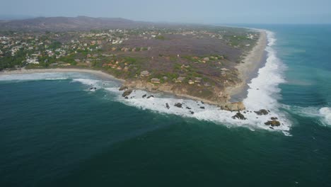 aerial view of waves crashing against the beach at punta zicatela