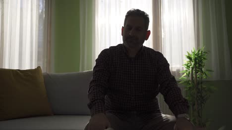 hombre deprimido solo en casa pensativo y sin esperanza.