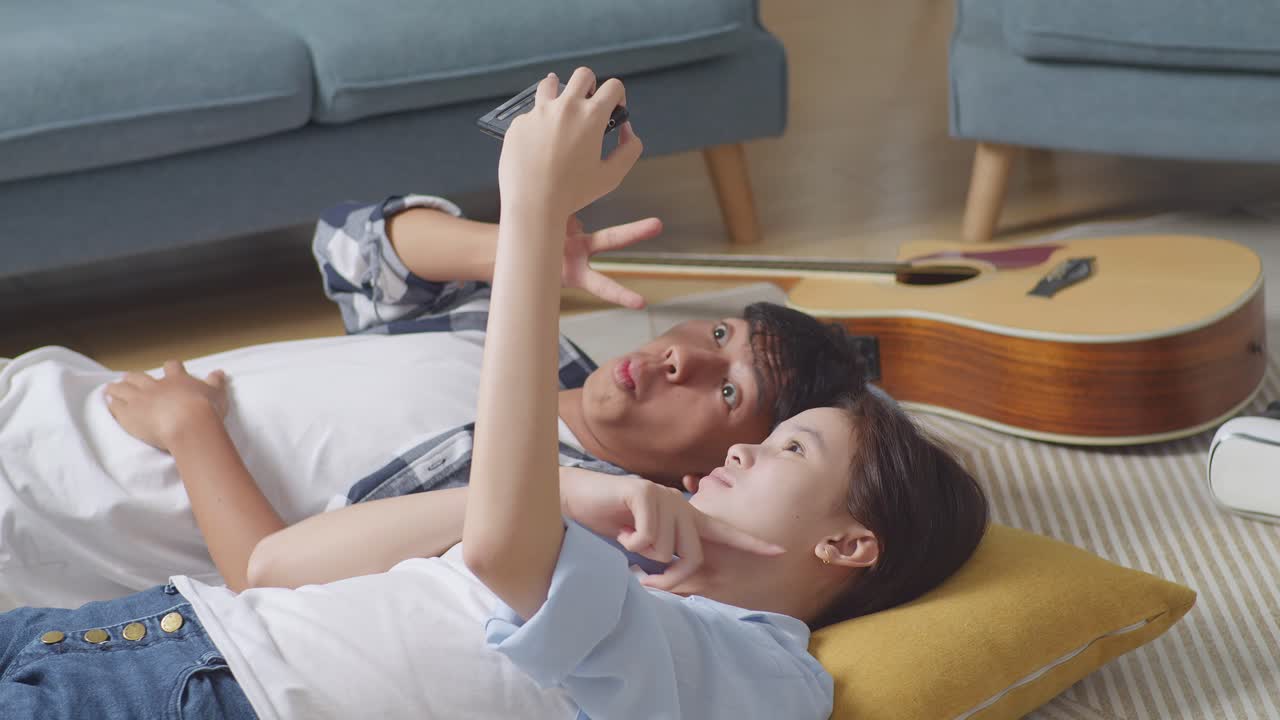 커플이 집에서 셀피를 찍고 재미를 느끼고 있습니다.