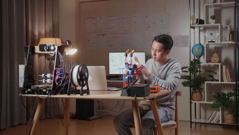 persona que trabaja en un proyecto de mano robótica utilizando una impresora 3d