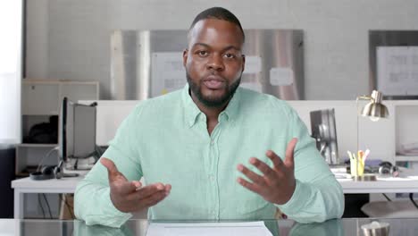 african american casual businessman having video call at office, talking and gesturing, slow motion