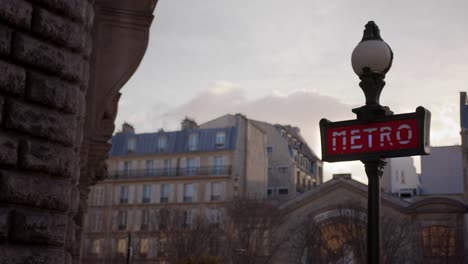 signo clásico del metro de parís con el paisaje urbano en el fondo al anochecer