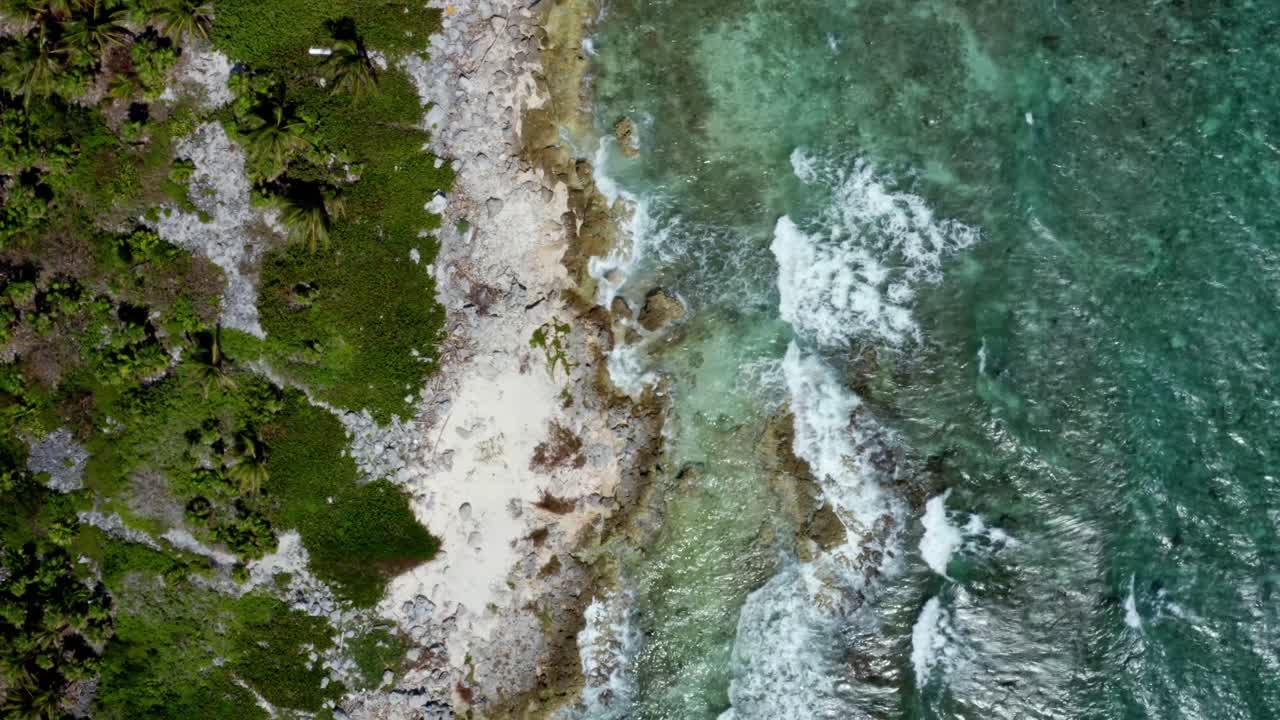 hermosa vista aérea de un dron a vista de pájaro de una playa tropical estéril con aguas turquesas claras, arena blanca, palmeras y olas que se estrellan contra las rocas cerca de riviera maya, méxico cerca de cancún
