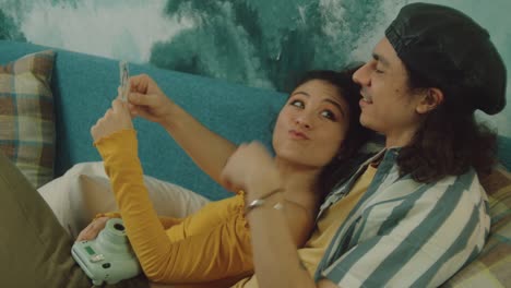 couple looking at instant photo on couch