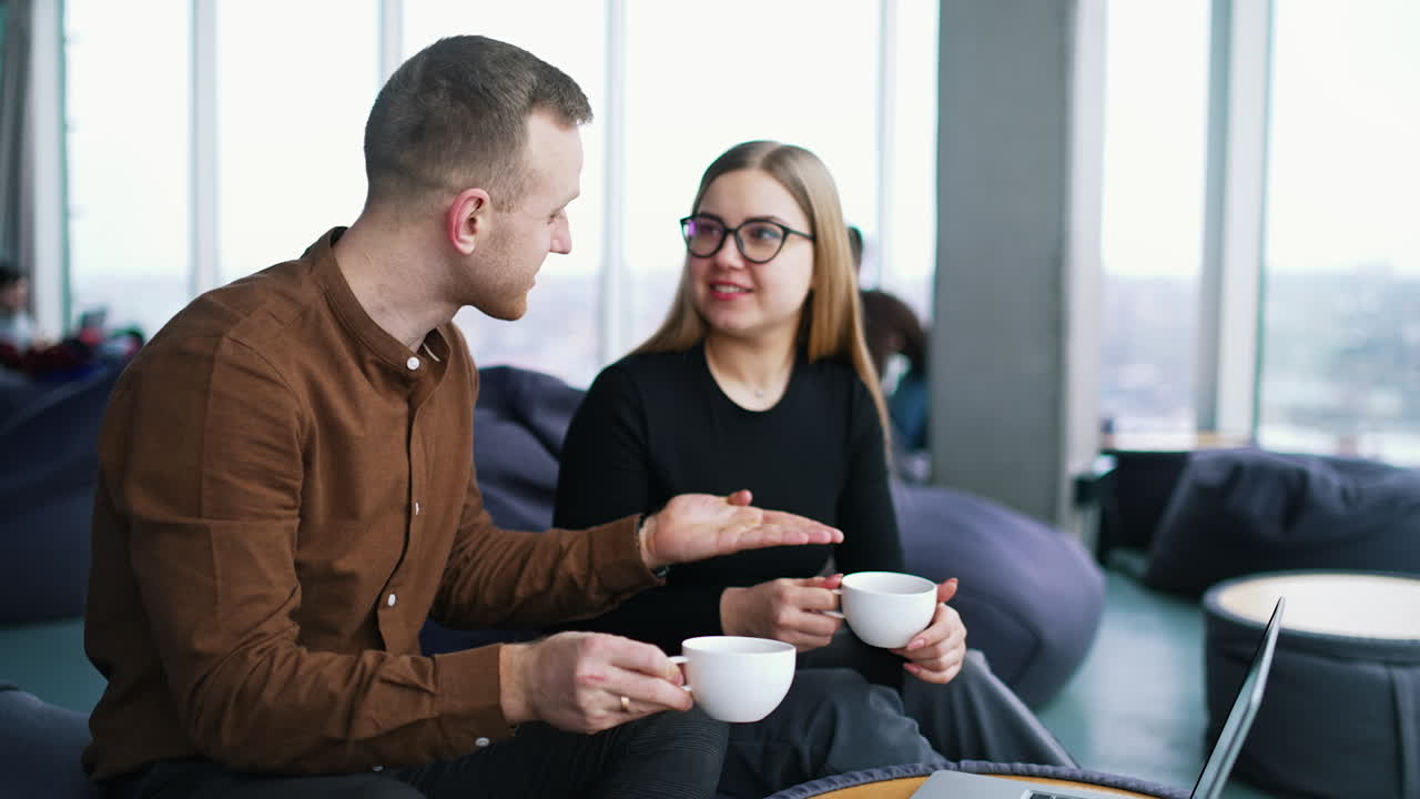 Business meeting of two professionals. Handsome businessman and beautiful businesswoman using laptop together in cafe