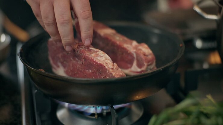 Koki Memasak Steak di Wajan