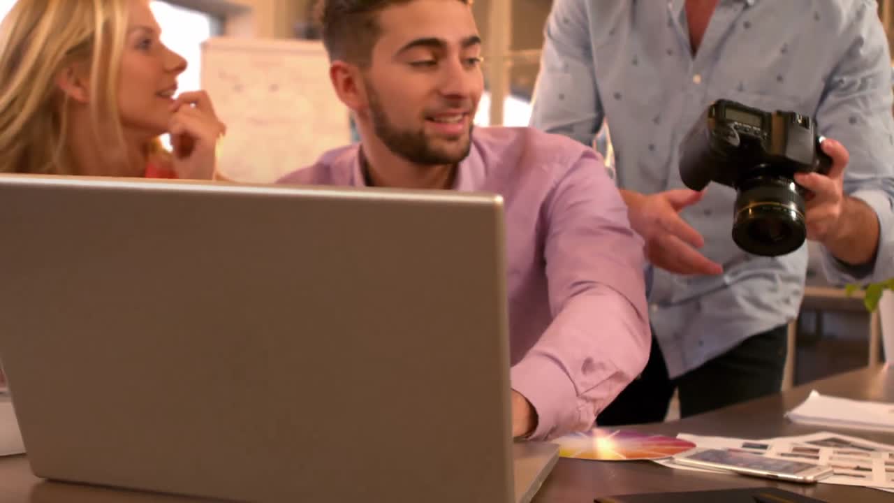 hombre de negocios creativo mostrando a sus compañeros de trabajo su cámara