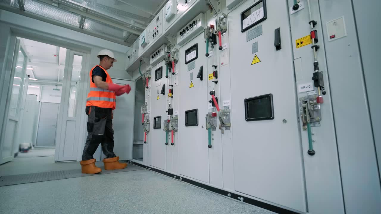 Electrical engineer working check the electric current voltage and overload at front of load center cabinet or consumer unit for maintenance in main power distribution system room.
