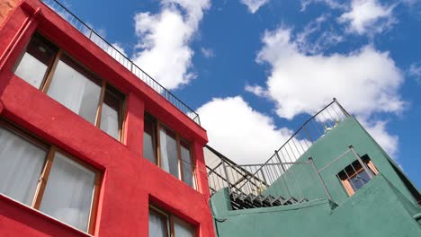 red and green buildings with balconies and a blue sky