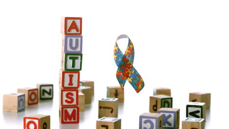 autism ribbon falling beside blocks spelling autism