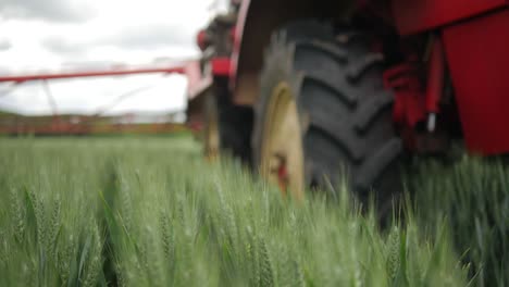 crop sprayer parked in green wheat field