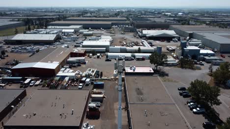 Revealing-Shot-of-the-Mobile-Cell-Tower-Surrounded-by-Warehouses-and-Car-Shops