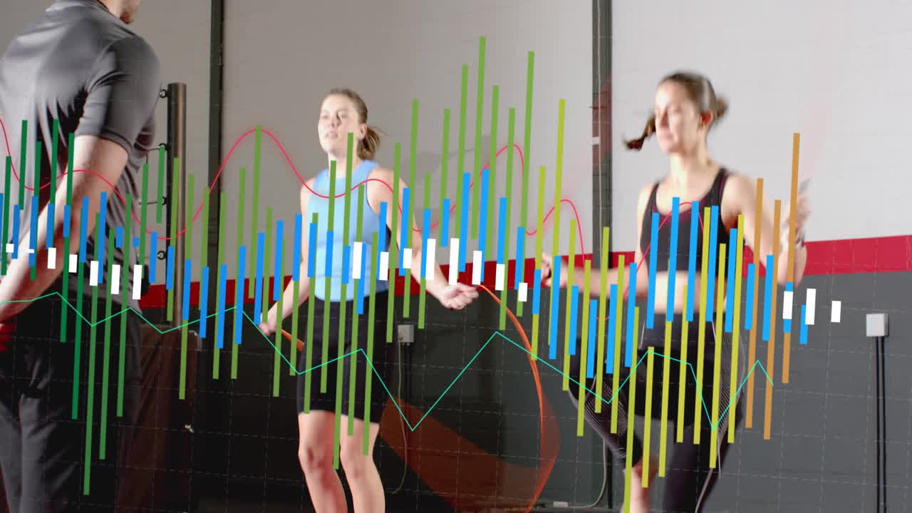 Coach cueing, two women skipping ropes in sync in gym, bars moving obscuring them for fitness