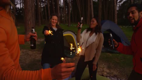 amigos divirtiéndose con chispas en el bosque 4k