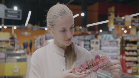 woman shopping for strawberries and bread at a supermarket