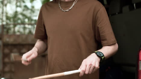 Man-with-drumsticks-outdoors