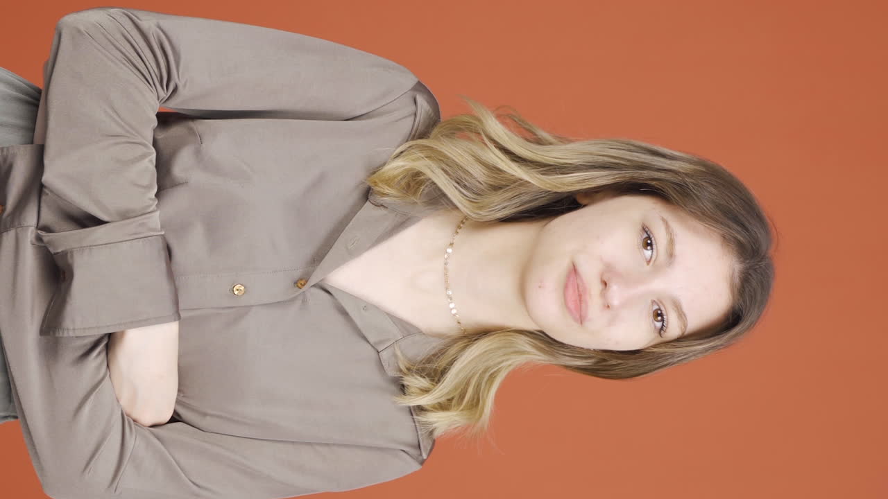 그녀가 듣는 뉴스를 좋아하지 않는 젊은 여성의 수직 비디오는 승인하지 않습니다.