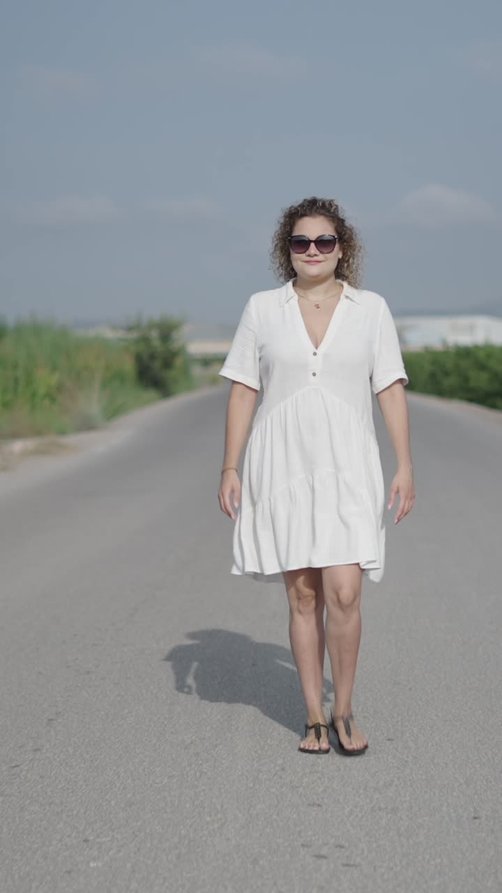 Woman in white dress walking on road