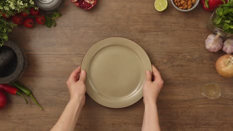 persona del cultivo poniendo el plato en la mesa de madera