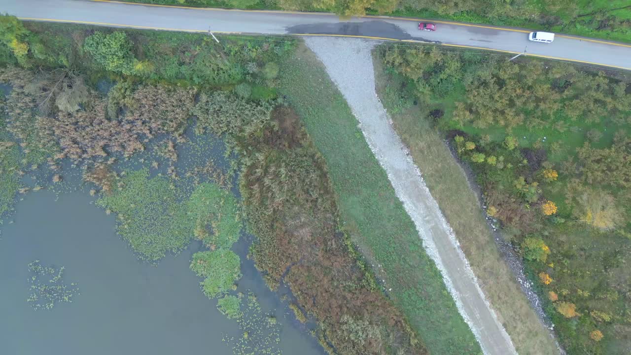 Aerial of bridge crossing calm river in lush green countryside landscape