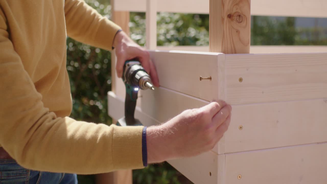 The craftsman lays the wooden boards flush and checks the work step