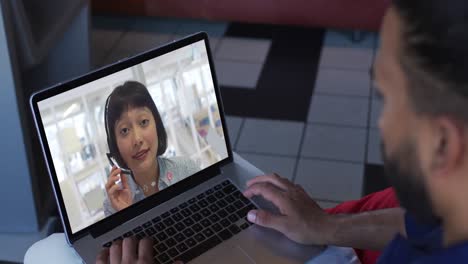 African-american-man-having-a-video-call-with-female-office-colleague-on-laptop-at-home