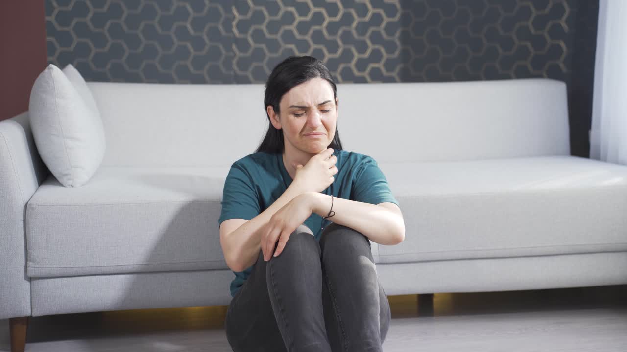 mujer enferma tosiendo apoyada en la pared. sin esperanza.
