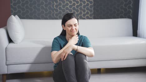 mujer enferma tosiendo apoyada en la pared. sin esperanza.