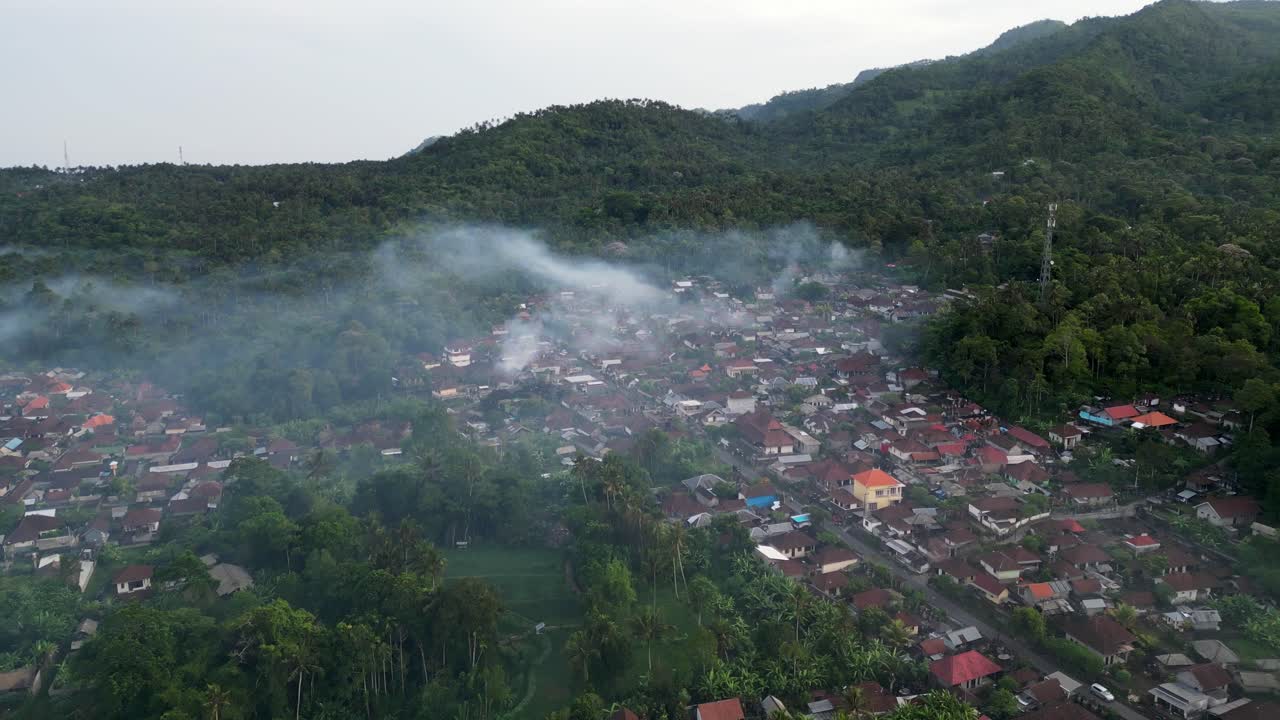 Drone terbang di atas sawah saat matahari terbit dengan kabut tipis
