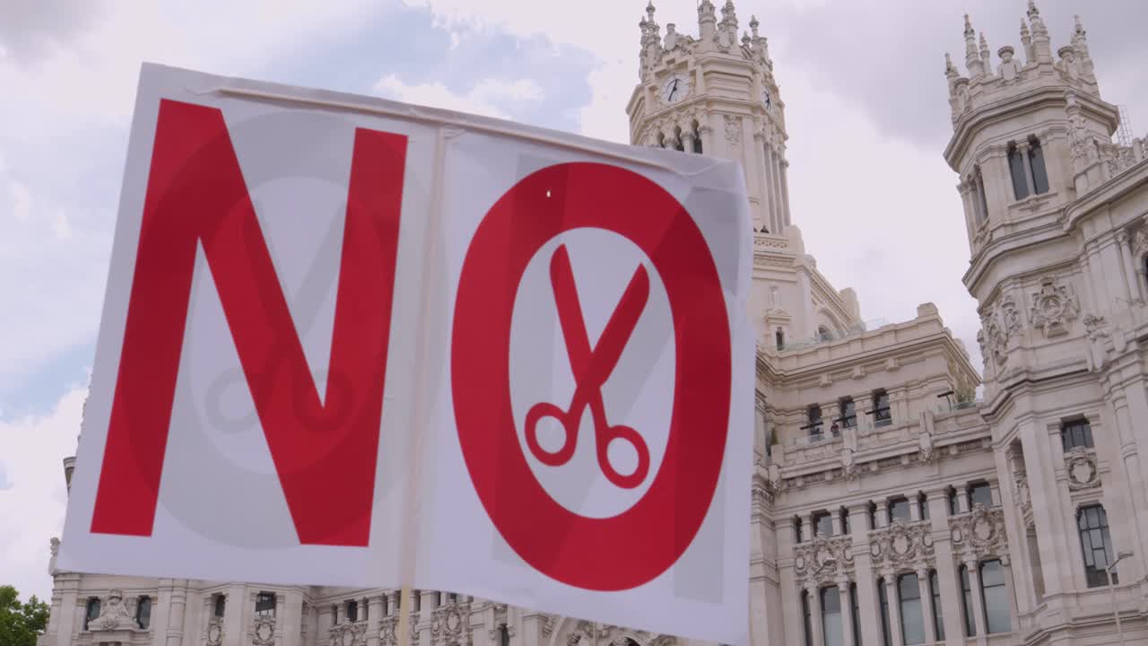 Protest Sign 'NO' with Scissors Against Budget Cuts