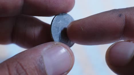 person showing indian currency, year of 1998 25 paise coin with backside printed rhino animal. internal shot, close up shot, stable shot, 4k.