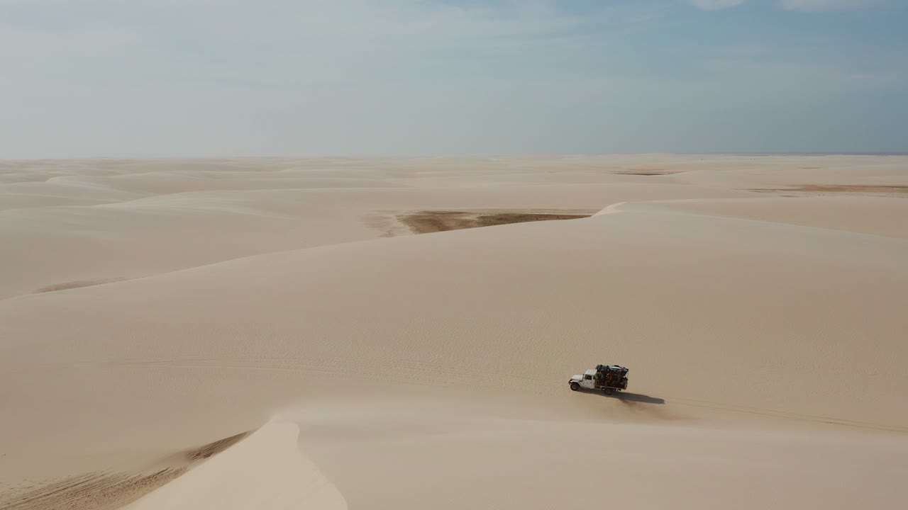 antena: un camión con kitesurfistas viajando a través de las dunas de lencois maranhenses en brasil, durante la estación seca