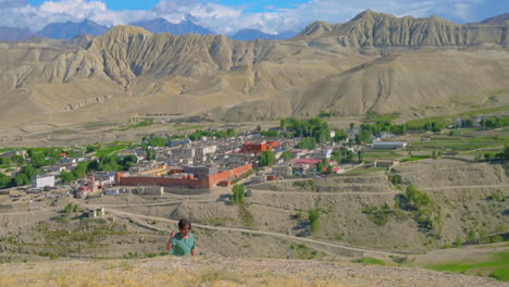 a tourist man walks upward hill enjoying beauty of lomanthang upper mustang nepal and its landscapes