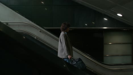 woman walking up escalator in a modern building