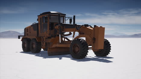 road grading machine on the salt desert road