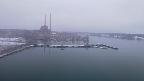 Chimney-silhouette-of-closed-coal-power-plant-on-Detroit-river-coast,-aerial-view