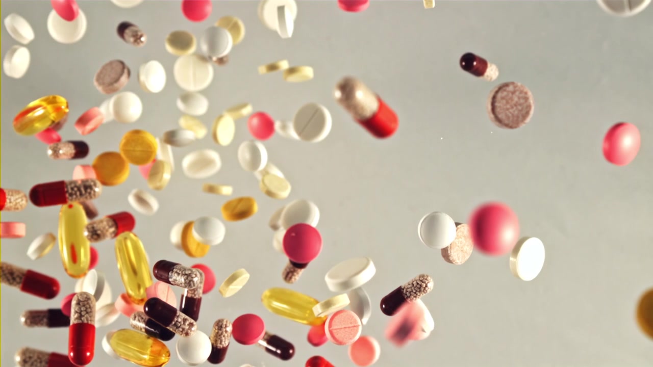 Pillole e capsule colorate che cadono al rallentatore
