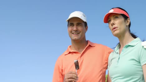 pareja feliz interactuando entre sí mientras juegan al golf