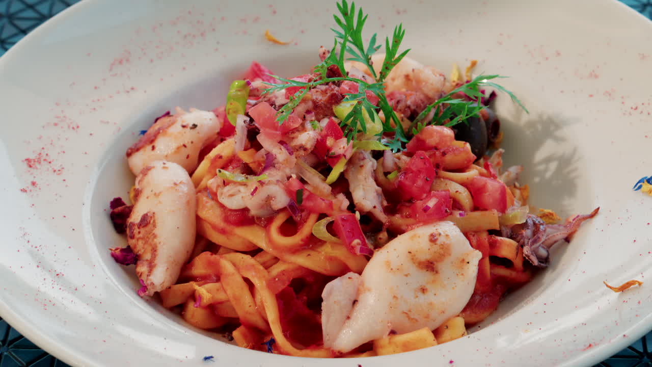 Close up of a seafood pasta dish with shrimp, squid, and tomato sauce, beautifully plated at a Mediterranean restaurant